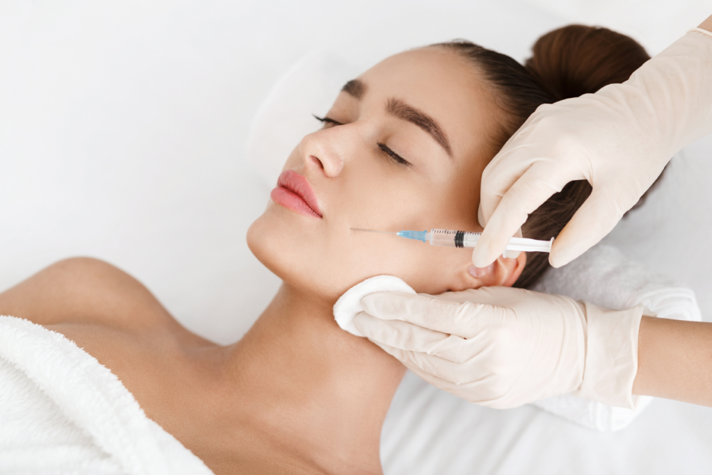 Cosmetic injector administering dermal filler to a patient's cheek at Canira Cosmetic in Aurora